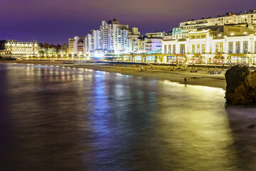 Seascape at night in Biarritz France in long photographic exposure. Beach and buildings at night in summer.
 - obrazy, fototapety, plakaty