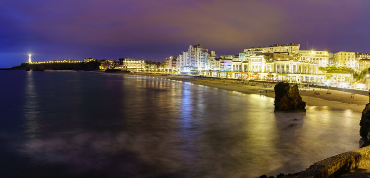 Seascape at night in Biarritz France in long photographic exposure. Beach and buildings at night in summer.

