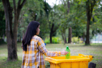 Woman hand picking up garbage plastic and Glass bottles for cleaning at park