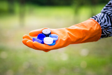 Woman hand picking up garbage plastic and Glass bottles for cleaning at park