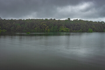 Obraz premium river serene back water with forests and dramatic cloudy sky