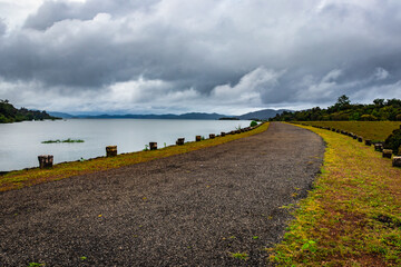 river serene back water with remote tarmac road and dramatic cloudy sky