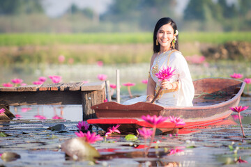 Beautiful girl in White Thai dress with red lotus flowers.Thai girl in retro Thai dress,Beautiful...