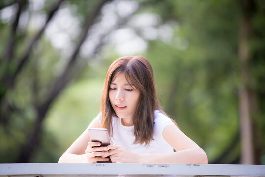 Beautiful Asian businesswoman uses a mobile phone to take a picture of herself while sipping coffee during a break to relax.