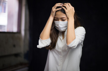 Portrait of an Asian woman putting on a sanitary face and locking herself in the room because of being ill from being infected with the Covid virus 19 and being stressed