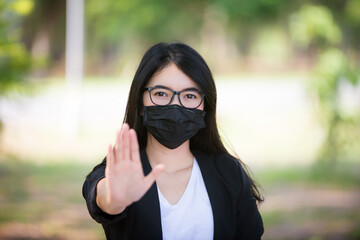 Corona virus, or Covid-19, is spreading all over the world. Portrait of an Asian woman wearing a black oil mask, anti-virus, or anti-Covid-19. Feeling stressed