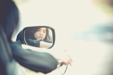 Asian woman sitting in a private car shows the keys in her hand.Selected focus