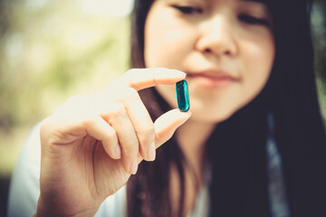Close up of woman putting pill in mouth. Sick female taking medicines, antidepressant, painkiller or antibiotic. Pharmacy and healthcare concept .Selected Focus.