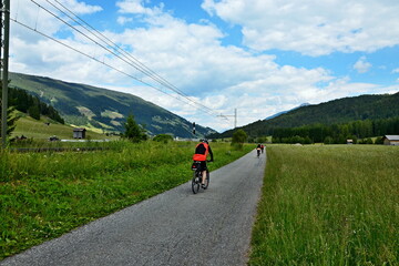 Fototapeta na wymiar Austrian Alps - cyclists on the cycle path along the river Draw