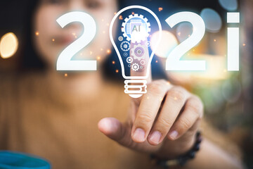 Young businesswoman touches an AI icon with a light bulb showing a cog in a business run. Creative ideas for analyzing business development approaches in 2021