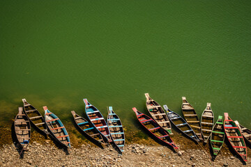 traditional wood fishing boats in many colors with lake transparent water