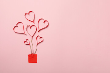 Concept of Valentine's day with decorative hearts and gift box on pink background