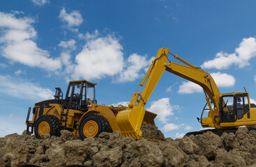 Excavator and Wheel loader are digging the soil in the construction site on the blue sky  background