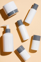 Cosmetic products for skin care on a beige background. Creams, serums, lotions with empty packaging. Beauty and spa concept.