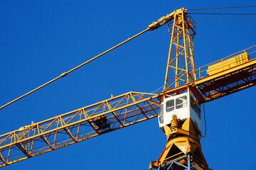 Crane. Self-erection crane against blue sky. Construction site. Industrial background.