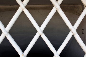 evocative image of texture of white intertwined mesh iron grate