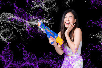 Portrait cheerful young asian woman holding plastic water gun Smiling and having fun playing in the water Songkran festival, Thailand. isolated on black background. Thai New Year's Day.