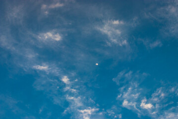 moon with bright blue sky and clouds at morning