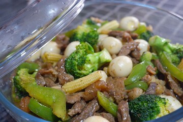 Beef with boiled quail eggs and variety of vegetables like broccoli, young corn and green bell pepper