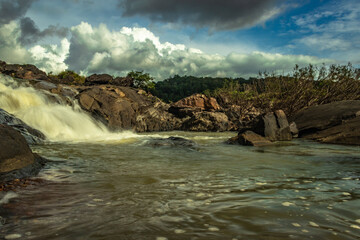waterfall in remote forest with dramatic sky from flat angle long exposure