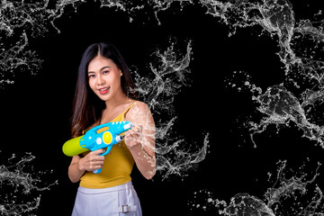 Portrait cheerful young asian woman Wearing a yellow tank top ,holding plastic water gun Smiling and having fun playing in the water Songkran festival, Songkran Thailand. isolated on black background.