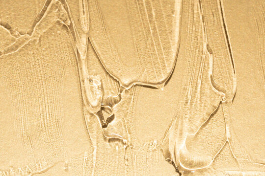 Luxury beauty serum texture detail on golden metallic background