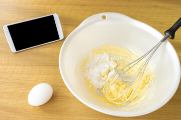スマートフォンを見てクッキーを作るイメージ