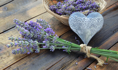 decorative metal heart with a bouquet of lavender flowers on wooden table