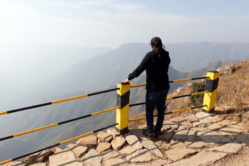 girl watching the beautiful mountain range from edge of mountain