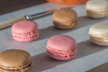Indulgent homemade chocolate and strawberry macaroons cooling down after baking in rows