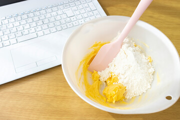 ノートパソコンを見てクッキーを作るイメージ