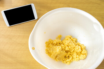 スマートフォンを見てクッキーを作るイメージ