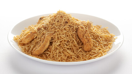 Indian spicy snacks (Namkeen) - Bikaneri Besan Bhujia in a white plate, made with chickpea flour (Besan), side view, against the white background.
