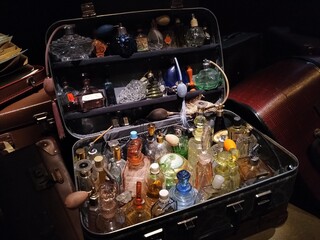 old suitcase with perfumes glass bottles