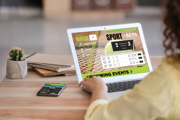 Young woman placing sports bet at home