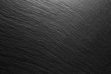 textured black slate background with spot of light