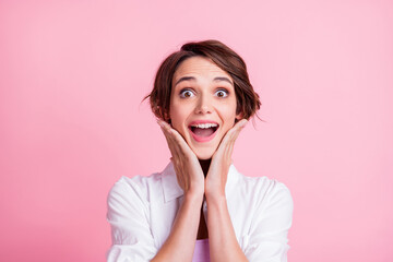 Photo portrait of amazed shocked happy girl touching cheeks opened mouth isolated on pink pastel color background