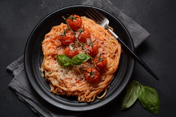 Spaghetti pasta with cherry tomatoes garnished with basil leaf