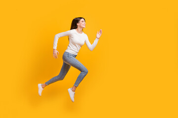 Fototapeta na wymiar Full size profile photo of optimistic nice girl jump run wear sweater jeans sneakers isolated on yellow color background
