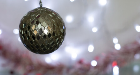 Christmas Holiday Background decorated with a silver bauble with bokeh lights behind.