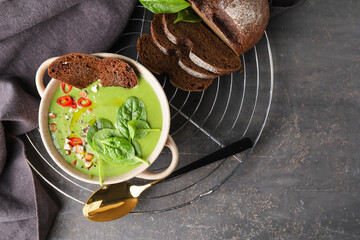 Bowl with tasty spinach soup on dark background