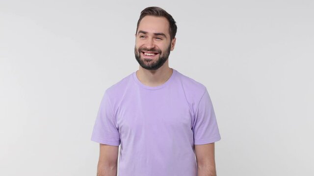 Smiling cheerful handsome bearded young man 20s years old in pastel violet casual t-shirt isolated on white color wall background studio. People sincere emotions lifestyle concept. Looking camera