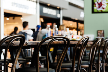 Wooden chairs in cafeteria in airport terminal. Selective focus