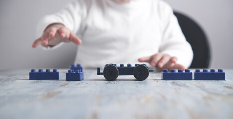 Little girl playing with construction plastic cubes.