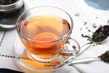 Glass cup of hot black tea on table