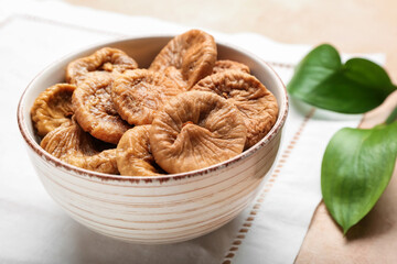 Bowl with tasty dried figs on table