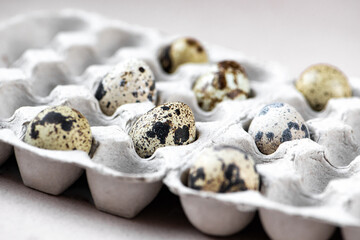 Quail spotted eggs in hald empty cardboard box. Organic eco food, Easter holiday. Selective focus
