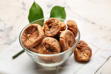 Bowl with tasty dried figs on table