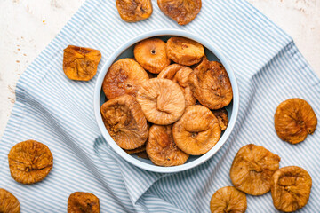 Bowl with tasty dried figs on table