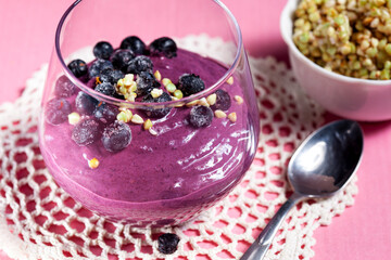 Vegan dessert, Green buckwheat sprouts mousse whipped with berries. Delicious healthy breakfast. On a pink background